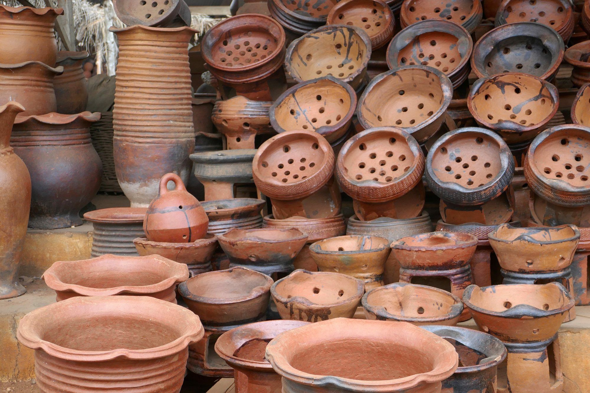 Poteries en terre cuite de Sè, au Bénin, exposées sur un étal.